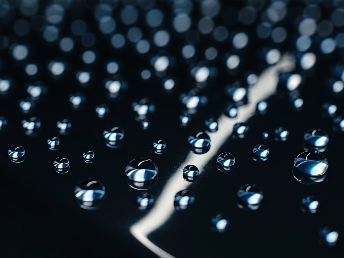 Macro view of water beads on coated paint